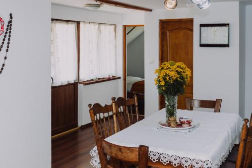 La Casieru في Bilbor: طاولة غرفة الطعام مع إناء من الزهور عليها