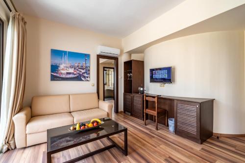 a living room with a couch and a table at Ladiko Suites - Faliraki in Faliraki