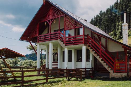 uma casa vermelha e branca com uma cerca de madeira em La Casieru em Bilbor