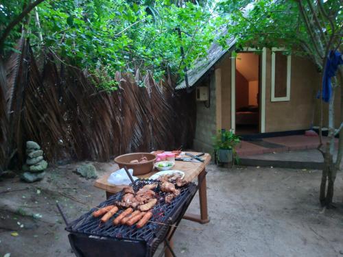 a grill with a bunch of hot dogs on it at By The C' Cabanas in Hikkaduwa