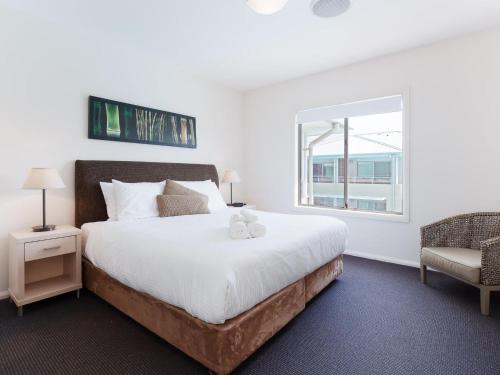 a bedroom with a large white bed and a window at Pacific Blue 245-265 Sandy Point Rd - Dual Key Access, air conditioned unit with resort facilities and linen supplied in Salamander Bay