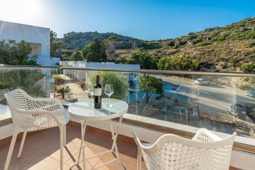 a white table and chairs on a balcony with a view at Ladiko Suites - Faliraki in Faliraki