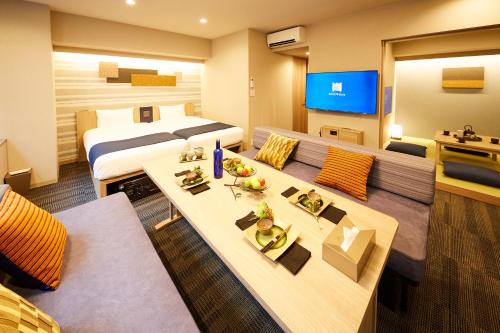 a hotel room with two beds and a tv at MONday Apart Premium HAMAMATSUCHO in Tokyo