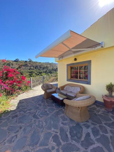 a patio with chairs and a table and a building at La cara Luna in Santa Brígida