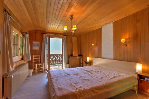 a bedroom with a large bed with a wooden ceiling at Les Chélettes in Chateau-d'Oex