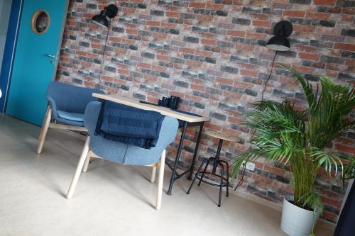 a table and chairs in front of a brick wall at Hafenstunde in Neubrandenburg