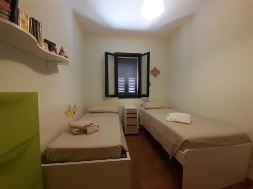 um pequeno quarto com 2 camas e uma janela em 439 HOUSE em Marina di Ragusa