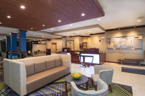 a living room filled with furniture and a tv at Holiday Inn Express and Suites Springfield Medical District, an IHG Hotel in Springfield