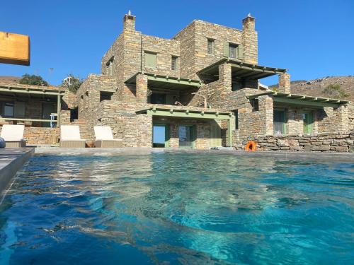 a large stone house with a swimming pool at Sea & Stone Villas in Koundouros