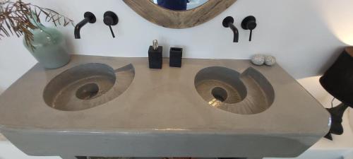 a table with two vases and a mirror on a wall at Santolia Art Suites in Oia