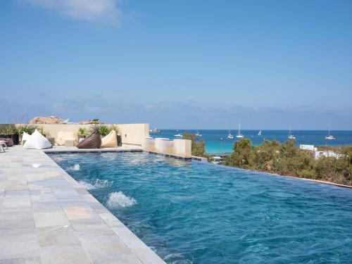 a swimming pool with the ocean in the background at Residence Saletta Mare in LʼÎle-Rousse