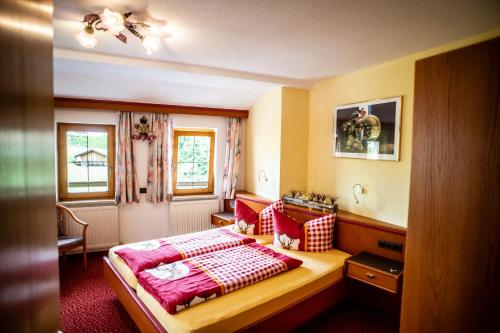 a bedroom with a bed with red and white pillows at Ferienhotel Angerhof in Fiss