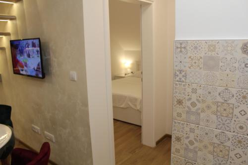 a room with a bedroom with a bed and a mirror at Kucica u Šumi in Užice
