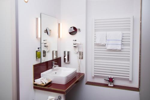 a bathroom with a white sink and a mirror at Waldidyll Rabenhorst in Homburg