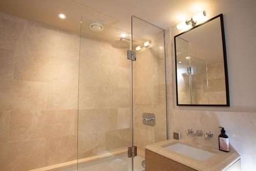 a bathroom with a shower, sink, and mirror at The Falcon Hotel in Northampton