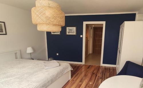 - une chambre avec un lit et un mur bleu dans l'établissement Comfortable Studio Old Town/New City, à Varsovie
