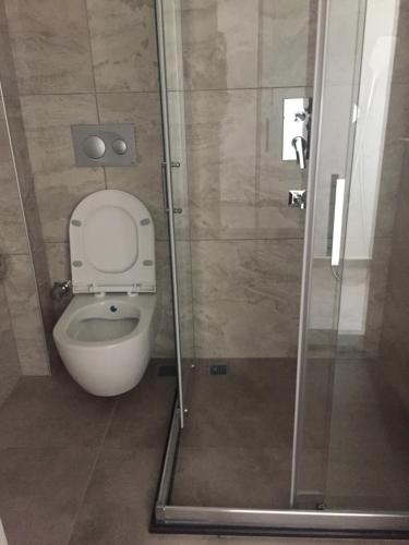 a bathroom with a toilet and a glass shower at Mediterranean Apart Fethiye in Mugla