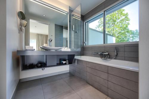 uma casa de banho com um lavatório e um espelho em Hostellerie Le Petit Manoir em Morges