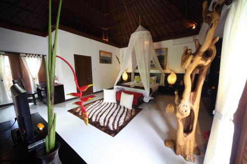a room with a bedroom with a bed and a tree at Baruna Sari Villa in Ubud
