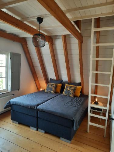 a bedroom with a blue bed in a attic at Het Schaager Waapen in Alkmaar