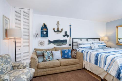 a bedroom with a bed and a couch and a chair at Waterside Suites in Saugatuck