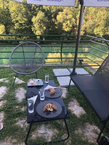 a table with a plate of food and two chairs at Hotel RIO VERDE in Podgorica