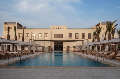 un hotel con piscina frente a un edificio en Kedma by Isrotel Design en Sede Boqer