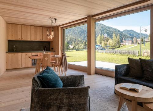 una cucina e un soggiorno con tavolo e sedie di Larix Lodge a La Villa