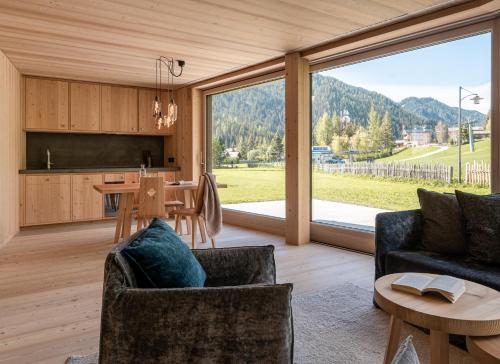 a kitchen and living room with a table and chairs at Larix Lodge in La Villa
