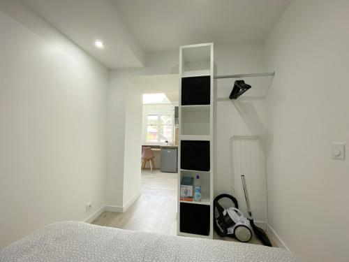 - une chambre avec une étagère sur le mur dans l'établissement Studio Ora - 22m² - climatisé avec balcon privatif, à Bassens