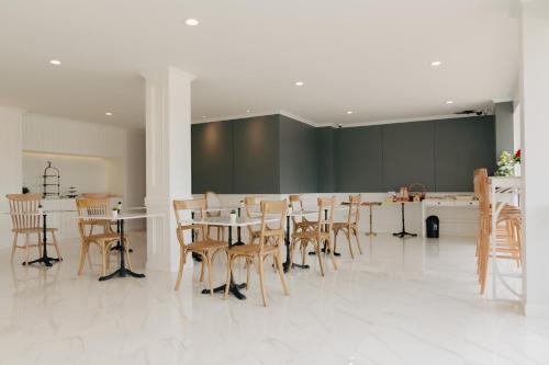 a dining room with wooden chairs and a table at Chanita Hotel Chumphon in Chumphon
