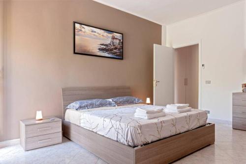 una camera con un letto e una foto appesa al muro di [FREE PARKING] Appartamento 5 STELLE elegante con suite a Livorno