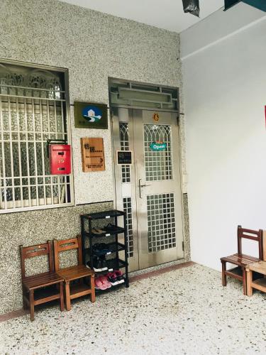 a room with two benches in front of a door at 枋寮枋居背包客棧Fang Ju Backpackers in Fangliao