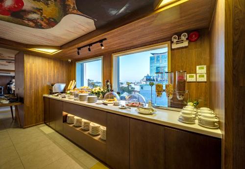 a kitchen with a counter with food and a window at Icon Saigon - LifeStyle Design Hotel in Ho Chi Minh City