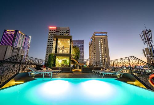 a pool with tables and chairs and a city skyline at Icon Saigon - LifeStyle Design Hotel in Ho Chi Minh City