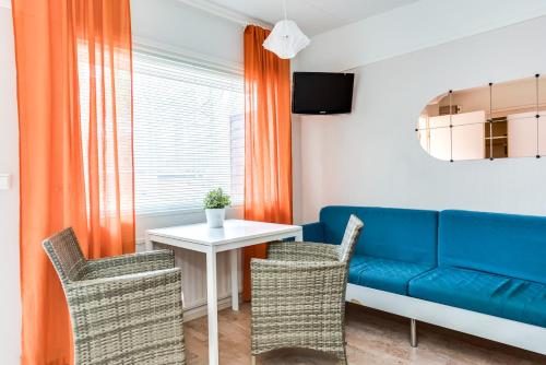 a living room with a blue couch and a table at Rantakallan Rinne rivitalohuoneet in Kalajoki