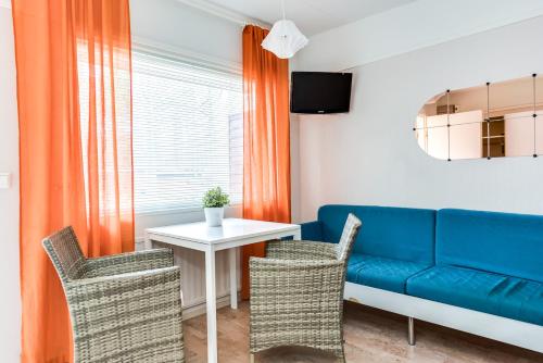 uma sala de estar com um sofá azul e uma mesa em Rantakallan Rinne rivitalohuoneet em Kalajoki