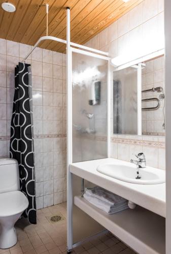 a bathroom with a sink and a toilet and a mirror at Rantakallan Rinne rivitalohuoneet in Kalajoki