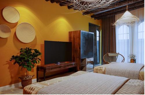 a living room with two beds and a flat screen tv at The wiltons hotel in Nam Ðịnh