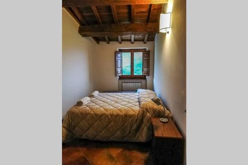 a bedroom with a bed and a table and a window at La Caprareccia in Fiumata