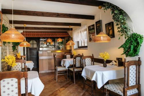 卡羅維發利的住宿－Pension Clara，餐厅设有2张桌子和椅子以及灯光