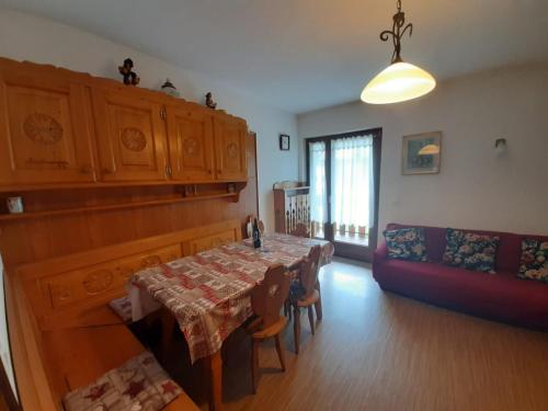 ein Wohnzimmer mit einem Tisch und einem Sofa in der Unterkunft Appartamento al Pelmo in Villanova