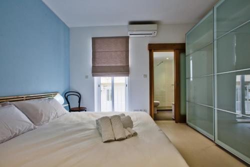 Un pat sau paturi într-o cameră la Bright and central 2 bedroom apartment in Sliema
