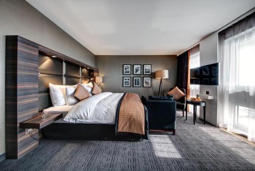 a bedroom with a large bed and a chair at Hotel Beaulac in Neuchâtel