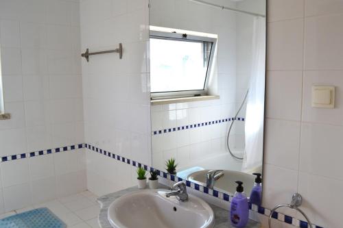 uma casa de banho branca com um lavatório e um espelho em Clem Terrace Flat em Portimão