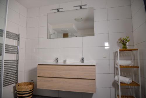 a white bathroom with a sink and a mirror at Alpine Appartement Top 8 by AA Holiday Homes in Tauplitz