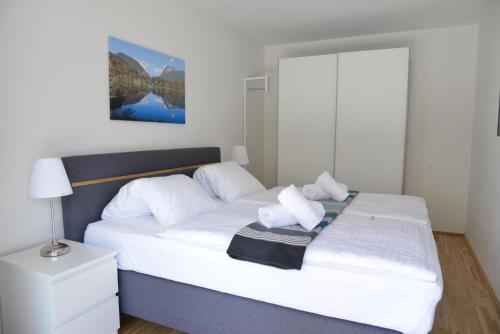 Schlafzimmer mit einem Bett mit weißer Bettwäsche und Kissen in der Unterkunft Alpine Chalet Ulla Top 3 by AA Holiday Homes in Bad Mitterndorf