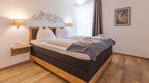 ein Schlafzimmer mit einem großen Bett mit einem Wandbild der Berge in der Unterkunft Alpine Appartement Top 2 by AA Holiday Homes in Tauplitz