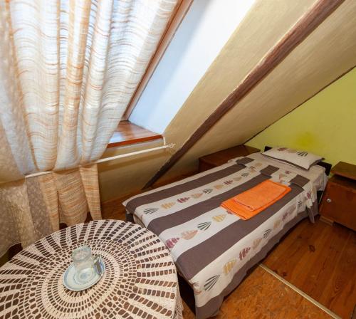 a room with a bed and a table and a window at Baltā māja in Pilsrundāle