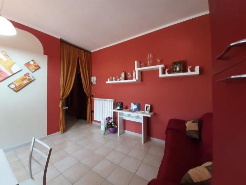 een woonkamer met rode muren en een wit bureau bij B&b Villa Santa Sofia by holidayngo in Paravati